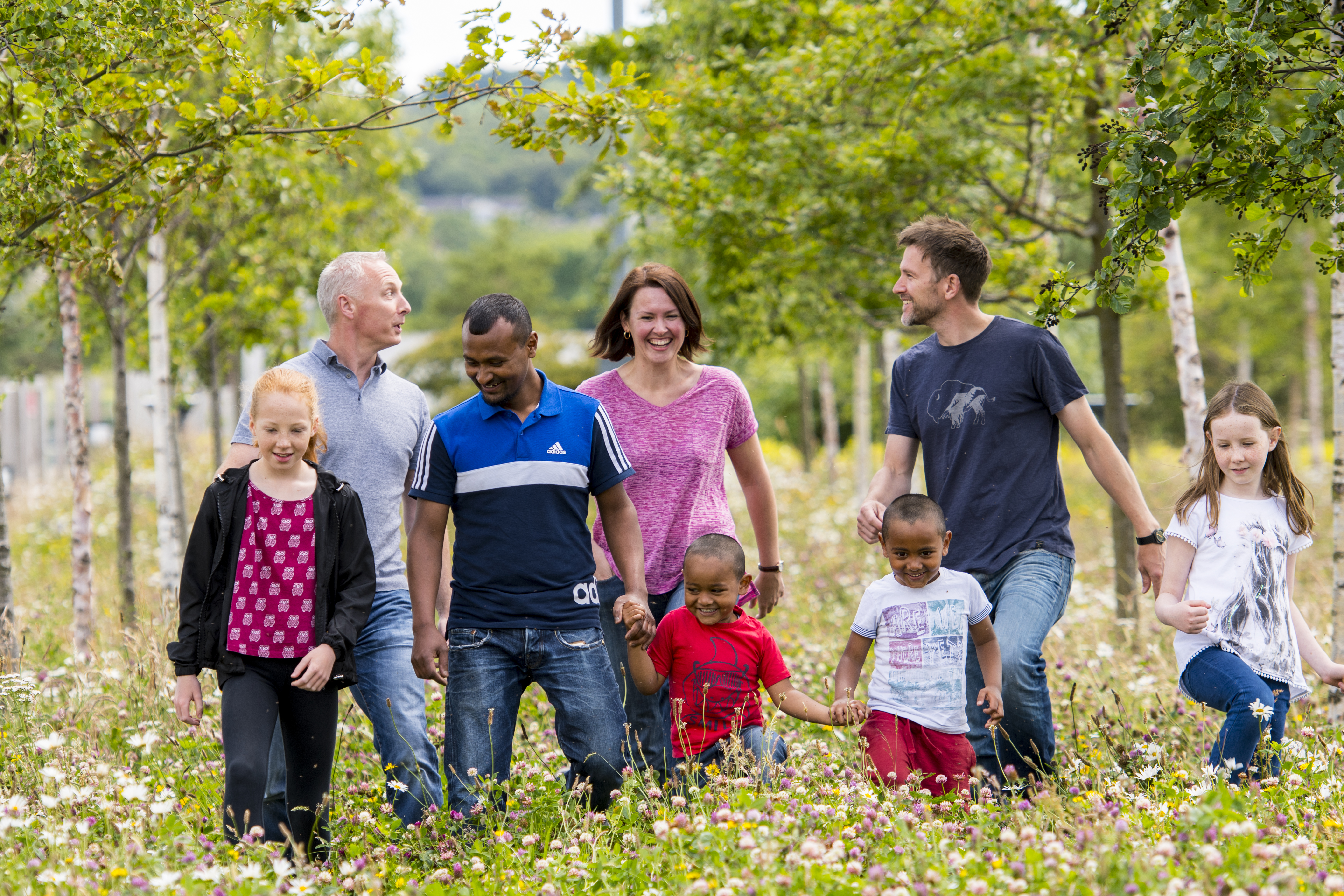 People walking through a field with wild flowers
